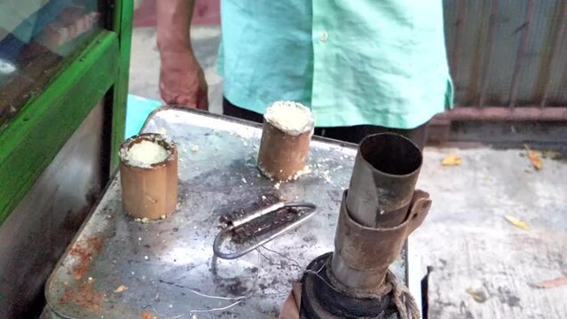 Cinematic shot of a conventional serving process of Indonesian snacks  called Kue Putu of rice cakes. These sweeta are made from rice flour and filled with brown sugar cooked by steaming