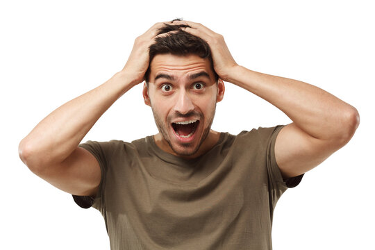 Handsome surprised man looking at the camera, shocked, holding hands on head