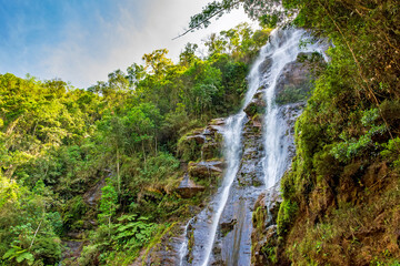 Waterfall among the dense vegetation and rocks of the rainforest in the state of Minas Gerais, Brazil