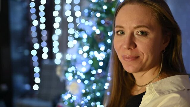 Amazing holiday moments: Happy woman posing on firtree background at home