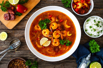 Louisiana soup gumbo with shrimp, chorizo and white rice on wooden table 