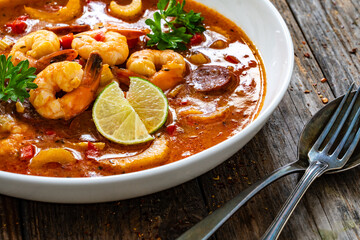 Louisiana soup gumbo with shrimp, chorizo and white rice on wooden table 