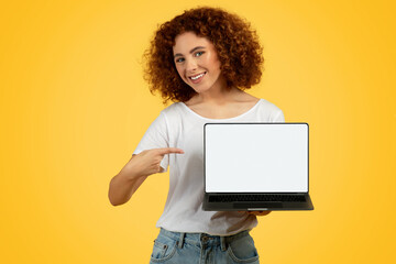 Smiling teen woman pointing finger at empty laptop screen