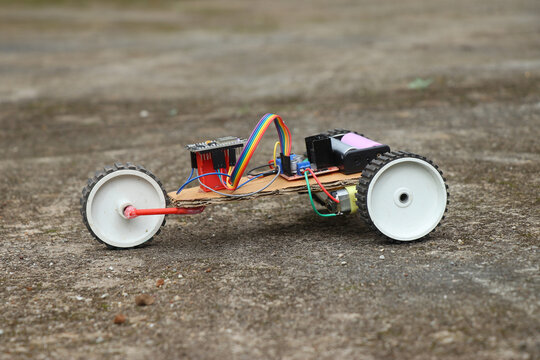 View of a robotic car having 3 wheels. Robot car that is controlled using a programmable micro controller board working prototype