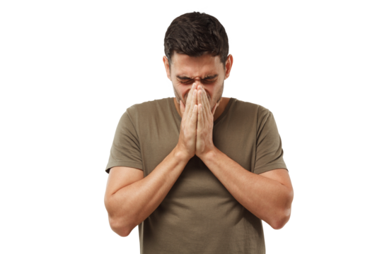 Sick young man covering face with hands, sneezing