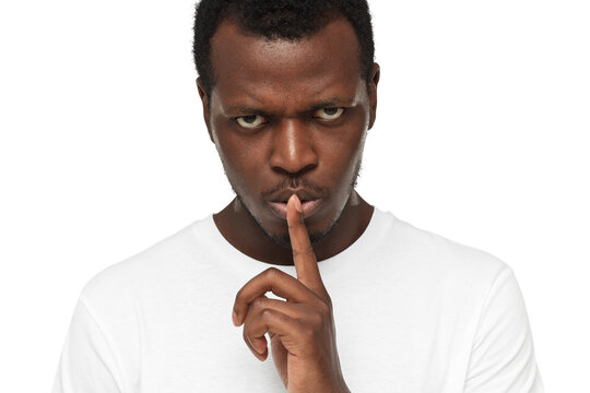 Close-up shot of angry african american man with shhh gesture, asking for silence or to be quiet
