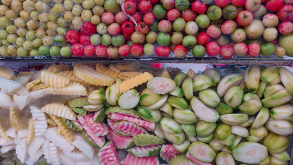 Close up of jujube, mango and guava in a glass display for making ambel bok or salted fruit snack, authentic khmer street food in Cambodia