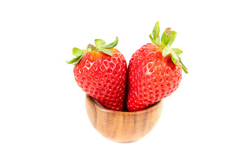 Two ripe strawberries sitting inside a wooden bowl
