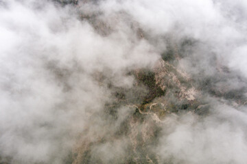 aerial view looking down through fog at the ground