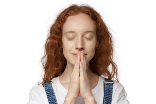 Close-up of curly christian redhead girl putting hands together as if she is praying
