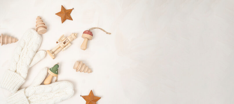Christmas holiday flat lay with copy space and wooden mushroom, Christmas tree and nutcracker ornaments on a cream neutral background
