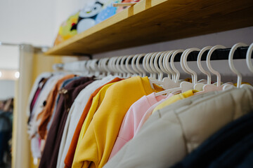 Bright clothes for children. Sweatshirts for girls and boys. Children's clothing store. Clothes on hangers. 
