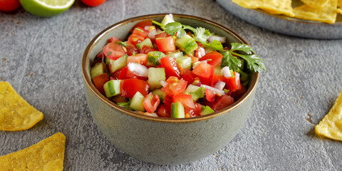 Pico de Gallo salsa in a bowl. Traditional Mexican cuisine dish with tomato, cucumber, onion and fresh coriander.