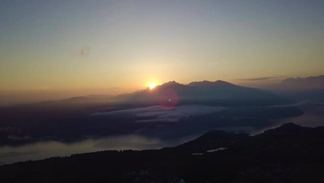 Sunrise behind a mountain peak in Switzerland filmed with a drone