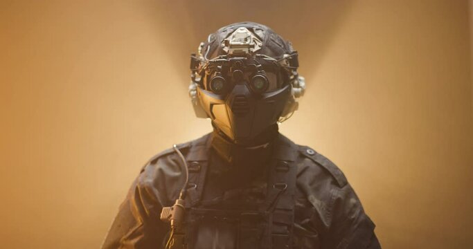 Soldier fully equipped with tactical gear and protection aiming his rifle at enemy with orange smoke in the background.