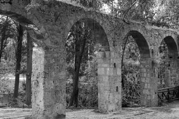 Black and white aqueduct, a watercourse arch over the Rodini Park lake and walking path located in central Rhodes