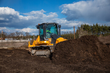 Fototapeta premium Bulldozer (crawler dozer) at work in the field.