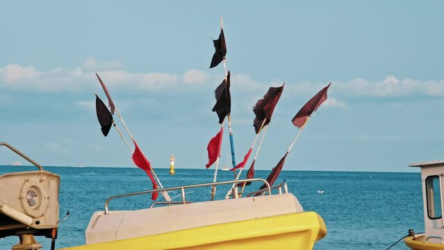 Undecked Handliner Fishing Vessel with Net Flags and Rusty Hooks Purse Sein Equipment Parked on Beach Sand at Seashore on Calm Day