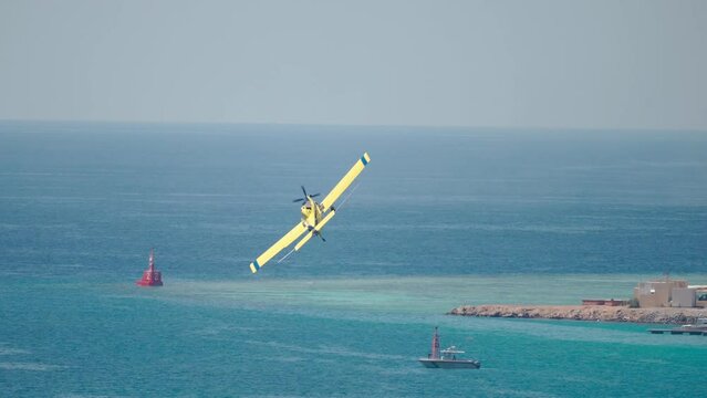 4k, small single-engine airplane performs aerobatic maneuvers at an airshow in the city port, Yanbu, Saudi Arabia