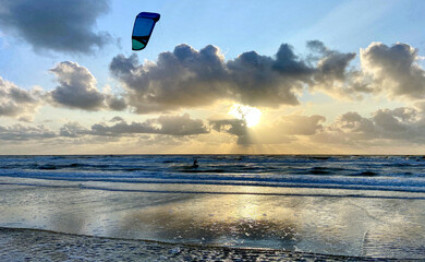 Kitesurfers on the rough Dutch North Sea at sunset. Egmond aan Zee, the Netherlands, Europe. 