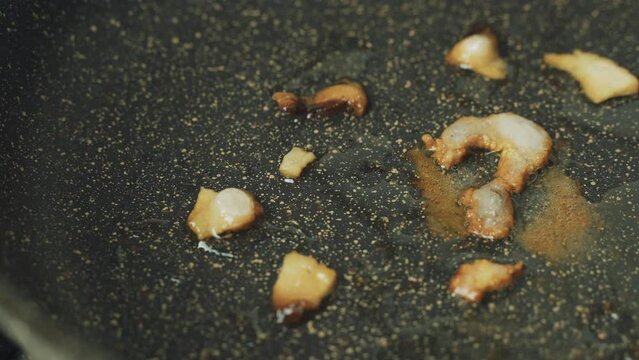 Lard with the symbol - Question mark is fried in a frying pan. Harmful, unhealthy food. The camera moves from left to right.