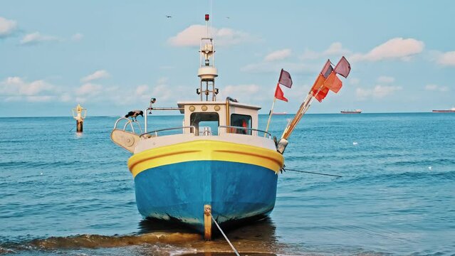 Undecked Handliner Fishing Vessel with Net Flags and Rusty Hooks Purse Sein Equipment Parked on Beach Sand at Seashore on Calm Day