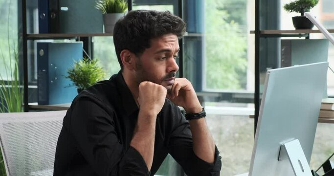 Contemplative Middle Eastern businessman conducts negotiations using a headset. His thoughtful demeanor highlights the complexities of the discussion, emphasizing dedication to finding solutions.