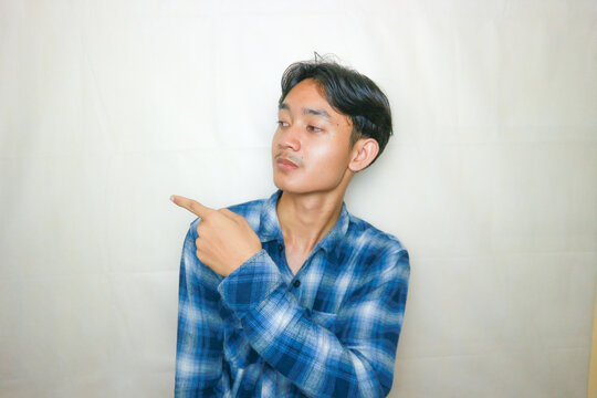 Random facial expressions of Asian Indonesian men in blue shirts and plain white backgrounds