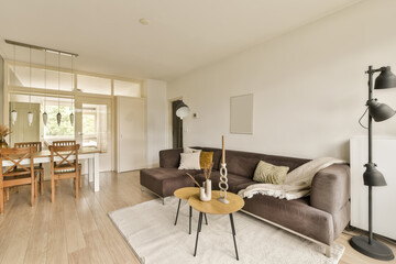 a living room with a couch, coffee table, and dining area in the fore - image taken from above