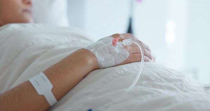 Woman hand, bed and iv drip in closeup, hospital or treatment for hydration, liquid or supplement. Person, healthcare and wellness for blood transfusion, anesthesia or pharma drugs for pain in clinic