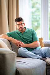 Portrait of a mid aged man relaxing on the sofa at home