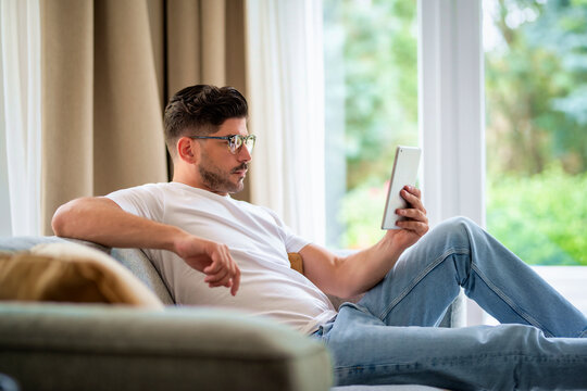 Shot of a man relaxing on the sofa at home and using digital tablet