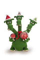 Three-headed dragon in New Year's hats and a red scarf knitted from green yarn. The dragon holds...