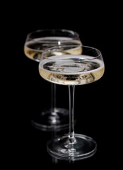Two champagne glasses on a black
