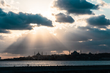 Silhouette of Istanbul with sunrays between the clouds and dramatic sky