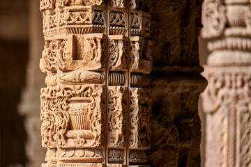 Stone columns with decorative bas relief of Qutb complex in South Delhi, India, close up pillars
