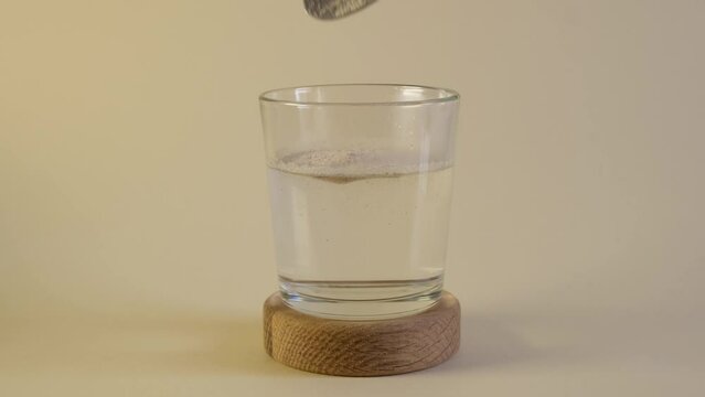 A spoonful of psyllium husk powder or psyllium flour is dissolved in glass of water. Natural food supplement to aid weight loss. Healthy Dietary Fiber. Trendy Superfood.