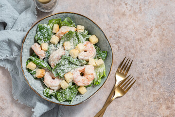 Fresh caesar salad on bowl with parmesan cheese and shrimps