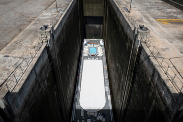 Barco numa barragem ou comporta de eclusa, estrutura que permite que os barcos subam ou desçam em canais ou rios