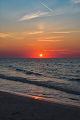 Beautiful colorful sunset over the sea. Sandy beach in the evening on the Polish Baltic Sea.