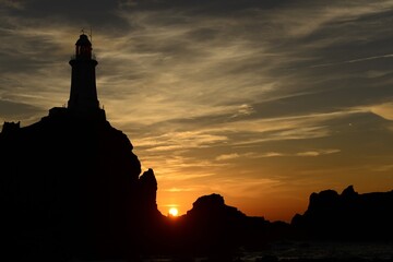 La Corbiere lighthouse, Jersey, U.K. Coastal landmark at sunset.