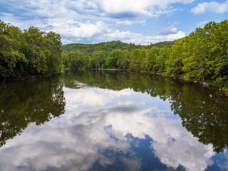 Shenandoah River South Fork with trees, sky and clouds reflecting in the still water in Virginia, USA.