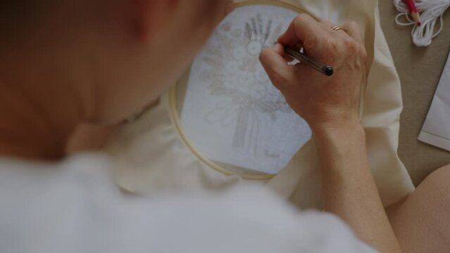 Woman sketching to designing pattern for handicraft embroidery with punch needle. Needlework concept.