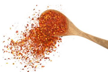 Spicy chili red pepper flakes, chopped, milled dry paprika pile in wooden spoon isolated on white,...