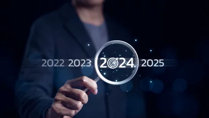 Fotobehang The 2024 year business goals concept. Businessman use magnifying glass search with 2024 wording for marketing monitor and business target planning for growth new year. Finding information, New ideas, © Supatman