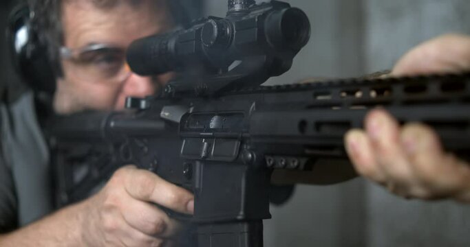 Firing an Assault rifle in super slow-motion 800 fps. Person shooting with AR-15 detail close-up of gun