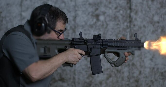 Firing a CQR rifle in super slow-motion 800 fps at shooting range. Shooter aiming and fires gun