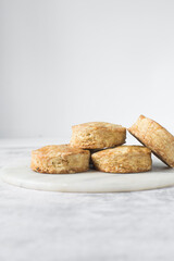Homemade scones on a white marble tray, freshly baked yogurt scones, buttermilk scones on a white background