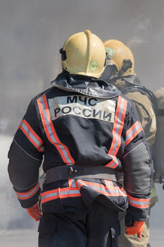 Back view with emblem Emercom of Russia on uniform firefighters of Ministry of Civil Defence, Emergencies and Disaster Relief of Russian Federation MChS. Kamchatka Peninsula, Russia - April 27, 2019