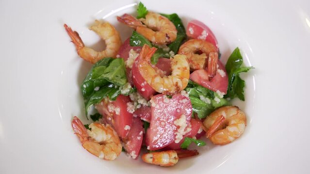 Serving fresh vegetable salad with cuscus and shrimps